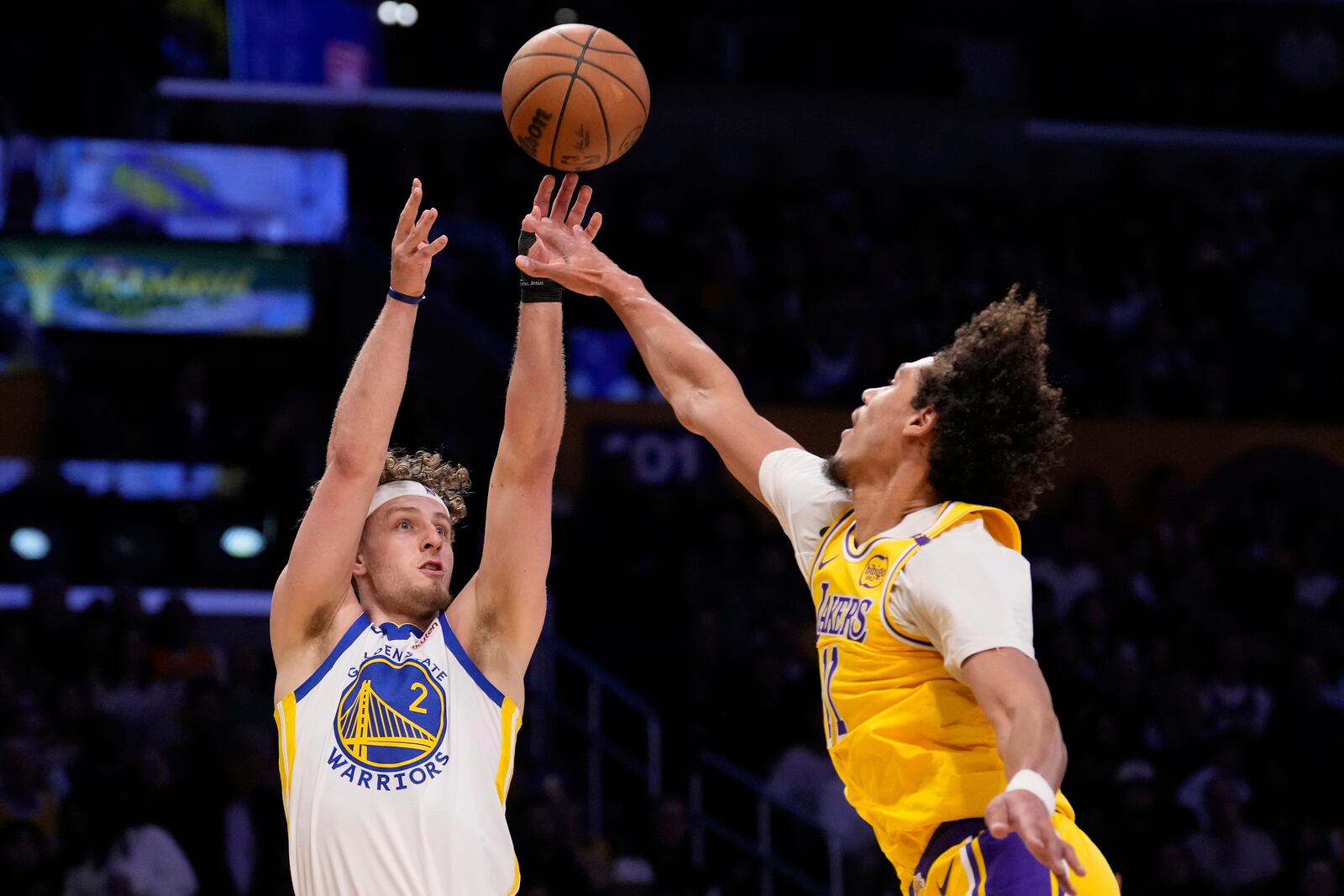 Golden State Warriors guard Brandin Podziemski, left, shoots as Los Angeles Lakers center Jaxson Hayes defends during the first half of an NBA basketball game Thursday, April 3, 2025, in Los Angeles. (AP Photo/Mark J. Terrill)