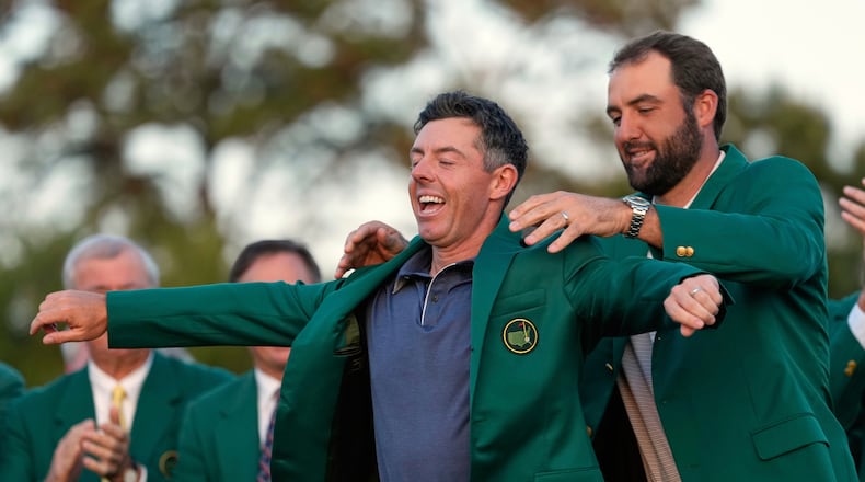FILE - Scottie Scheffler puts the green Jacket on winner, Rory McIlroy, of Northern Ireland, at the Masters golf tournament, April 13, 2025, in Augusta, Ga. (AP Photo/Ashley Landis, File)