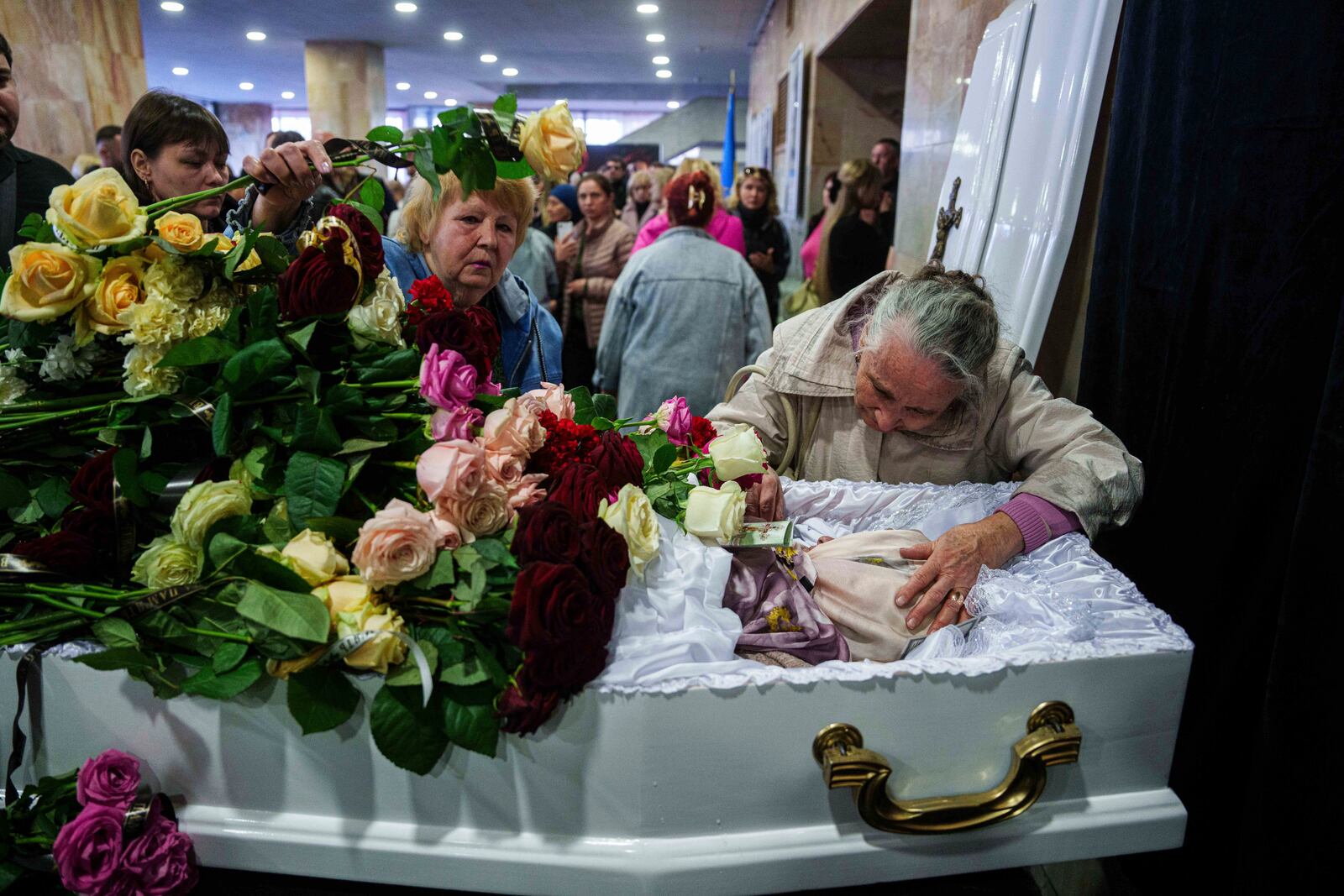 Mother Natalia says goodbye to her daughter Olena Kohut, an orchestra musician who was killed in a deadly Palm Sunday Russian attack on Sumy on April 13, during a farewell ceremony in Sumy, Ukraine, April 15, 2025. (AP Photo/Evgeniy Maloletka)