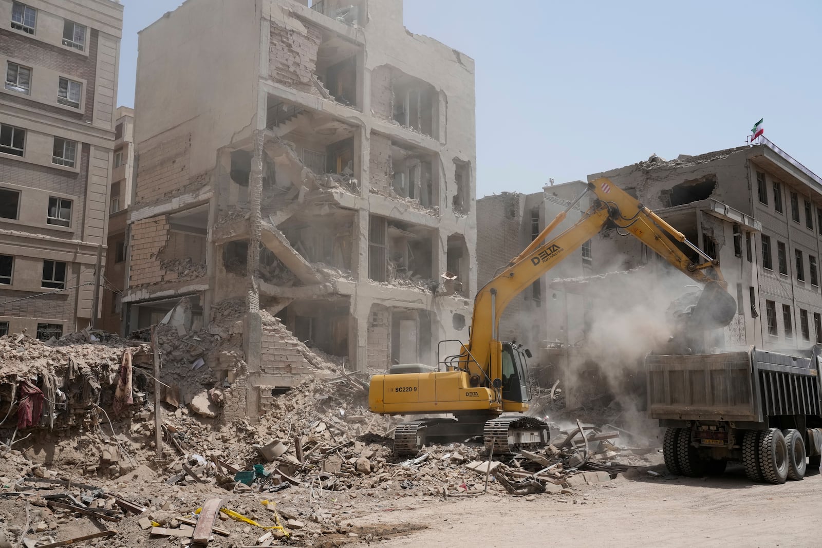 An excavator removes the rubble of a destroyed building hit by an Israeli airstrike on early Tuesday, in Tehran, Iran, Thursday, June 26, 2025. (AP Photo/Vahid Salemi)