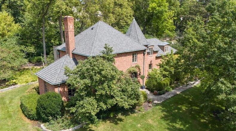 The brick French revival style home has been extensively updated and sits on a wooded lot within walking distance to Oakwood shops and schools