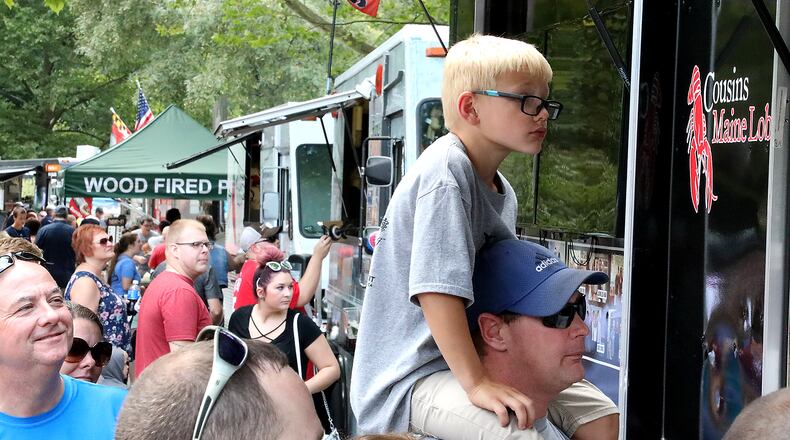 Ross Conrad sits on the shoulders of his father, David, as they wait in line at a food truck during the Springfield Rotary Gourmet Food Truck Competition.