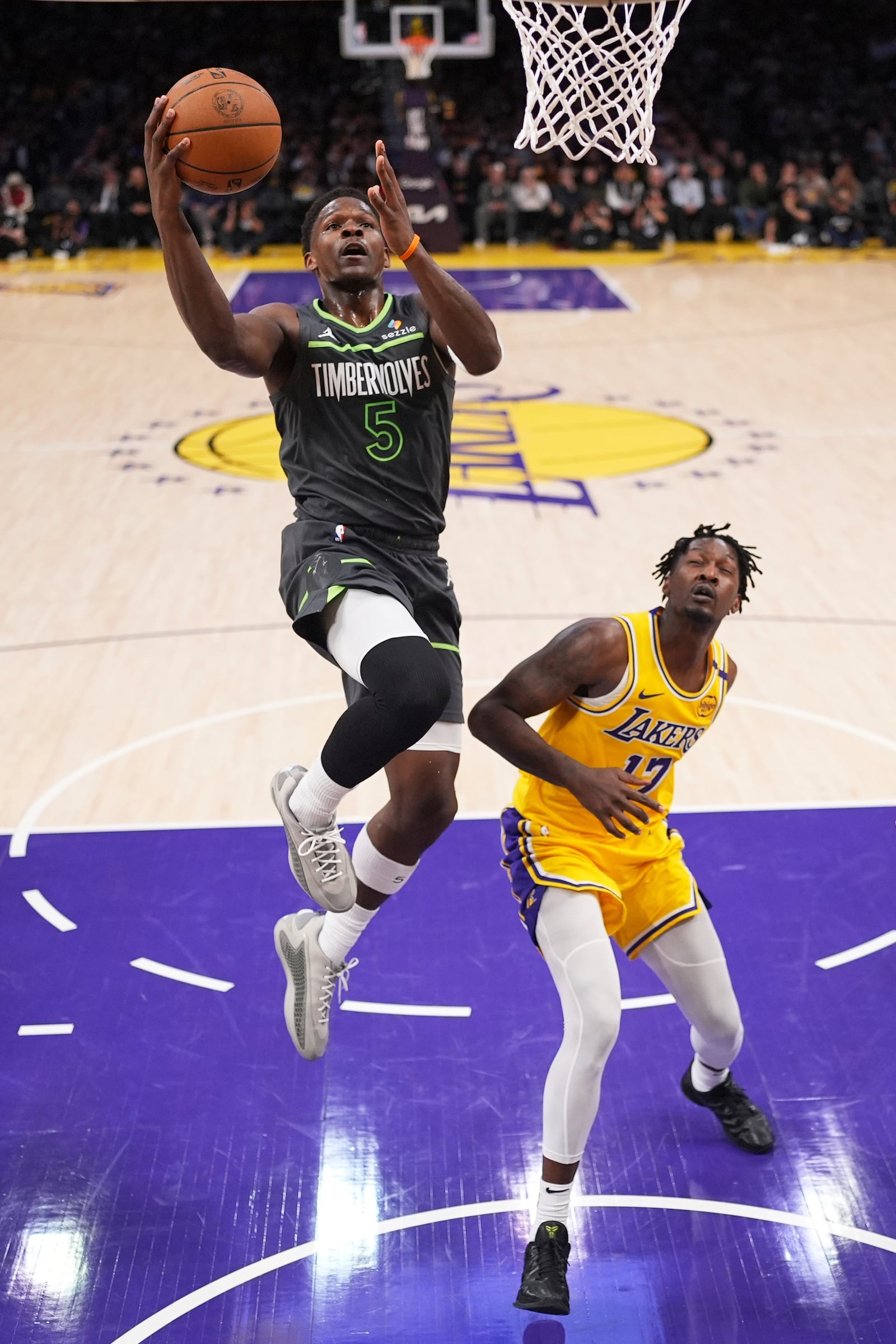Minnesota Timberwolves guard Anthony Edwards, left, shoots as Los Angeles Lakers forward Dorian Finney-Smith defends during the first half in Game 5 of an NBA basketball first-round playoff series Wednesday, April 30, 2025, in Los Angeles. (AP Photo/Mark J. Terrill)