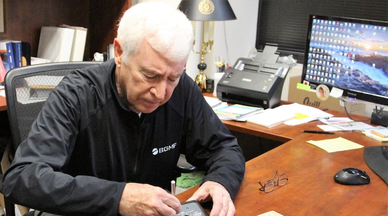Bill Groeber a CPA with Bennett, Groeber, Mullen, Feltner Co. showcases an old adding machine given to him by a client. Groeber said much has changed in his line of work since he got his first accounting job 50 years ago. HASAN KARIM/ Staff