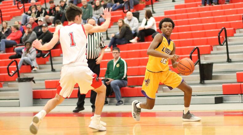 Emmanuel Christian Academy s Jason Channels drives past Tri-County North’s Preston Lairson during their Division IV sectional first round game at Troy High School on Saturday. The Lions won 57-47. CONTRIBUTED PHOTO BY MICHAEL COOPER