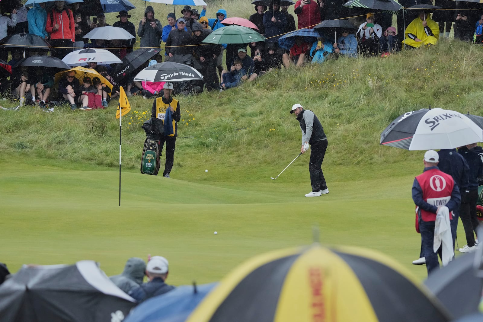 Scottie Scheffler of the United States chips onto the 8th green during the first round of the British Open golf championship at the Royal Portrush Golf Club, Northern Ireland, Thursday, July 17, 2025. (AP Photo/Jon Super)