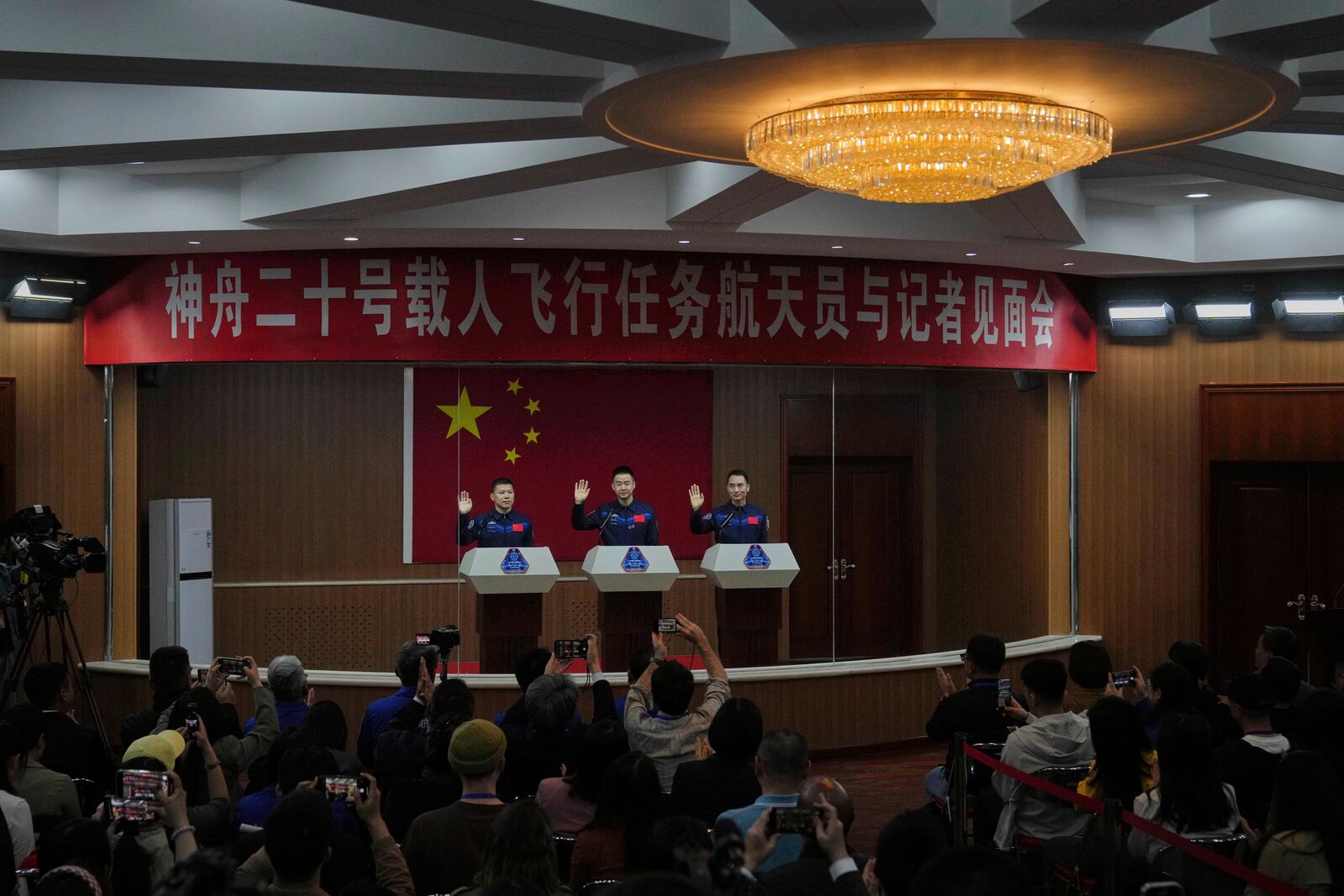 Chinese astronauts for the upcoming Shenzhou 20 mission from left, Wang Jie, captain Chen Dong and Chen Zhongrui wave as they meet with the press at the Jiuquan Satellite Launch Center in northwest China, Wednesday, April 23, 2025. (AP Photo/Andy Wong)