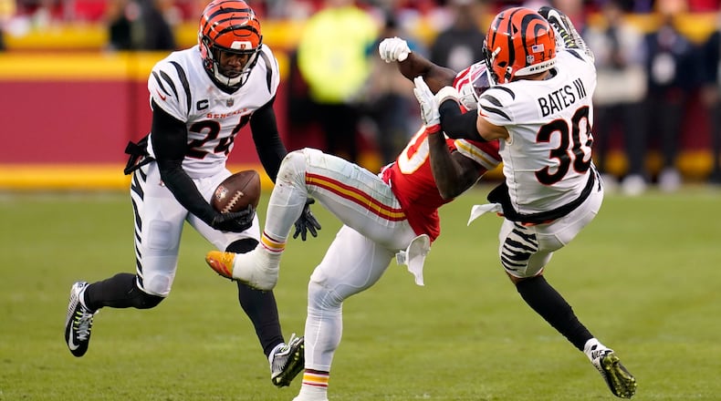Cincinnati Bengals safety Vonn Bell (24) intercepts a pass intended for Kansas City Chiefs wide receiver Tyreek Hill, center, as Bengals free safety Jessie Bates (30) defends during overtime in the AFC championship NFL football game, Sunday, Jan. 30, 2022, in Kansas City, Mo. The Bengals won 27-24. (AP Photo/Paul Sancya)