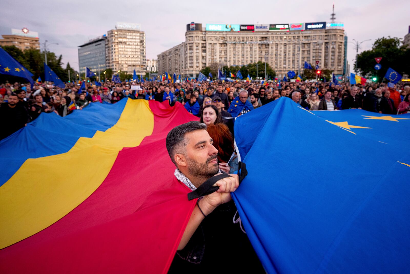 FILE - Demonstrators hold large Romanian and European Union flags during a pro-EU rally ahead of the second round of the presidential election redo in Bucharest, Romania, Friday, May 9, 2025. (AP Photo/Andreea Alexandru, File)