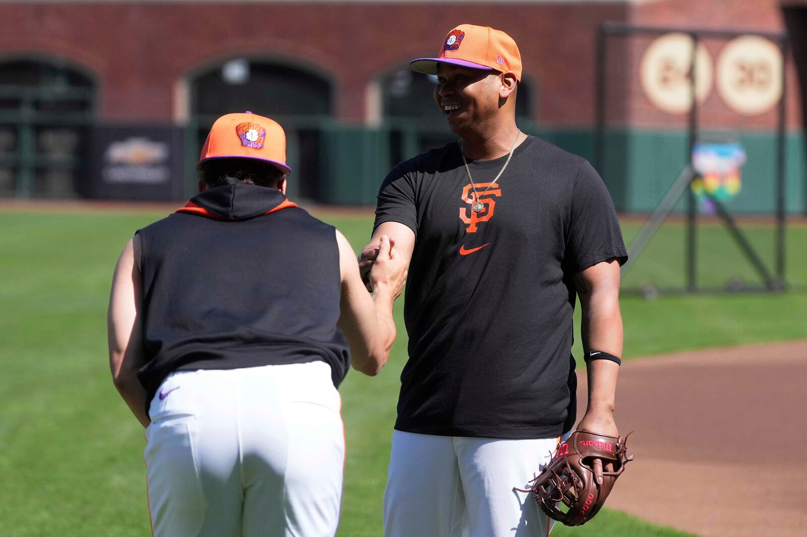 San Francisco Giants' Willy Adames, left, talks with Rafael Devers while warming up before a baseball game against the Cleveland Guardians in San Francisco, Tuesday, June 17, 2025. (AP Photo/Jeff Chiu)