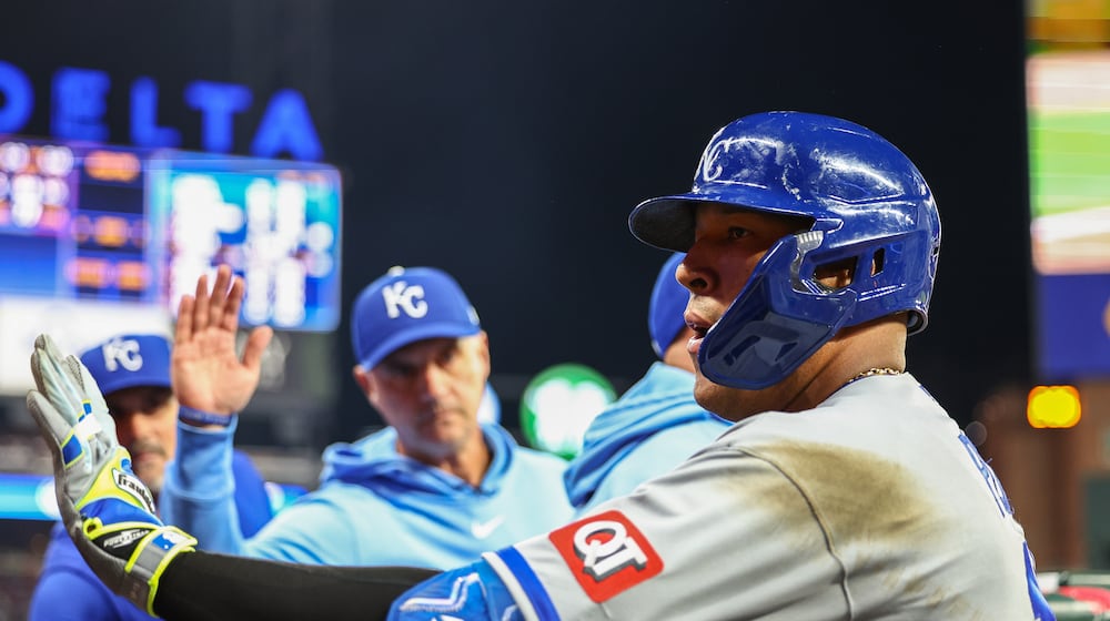 Kansas City Royals' Salvador Perez high-fives teammates in the dugout after hitting a solo home run in the seventh inning of a baseball game against the Atlanta Braves, Saturday, March 28, 2026, in Atlanta. (AP Photo/Colin Hubbard)
