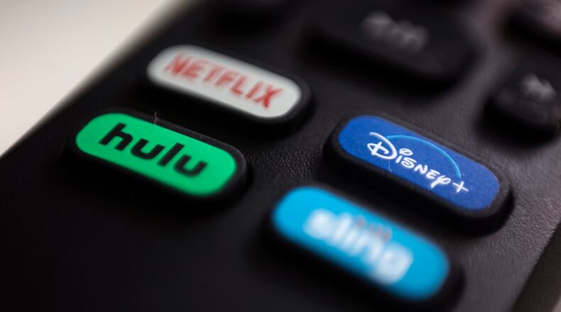 FILE - The logos for streaming services Netflix, Hulu, Disney Plus and Sling TV are pictured on a remote control on Aug. 13, 2020, in Portland, Ore. (AP Photo/Jenny Kane, File)