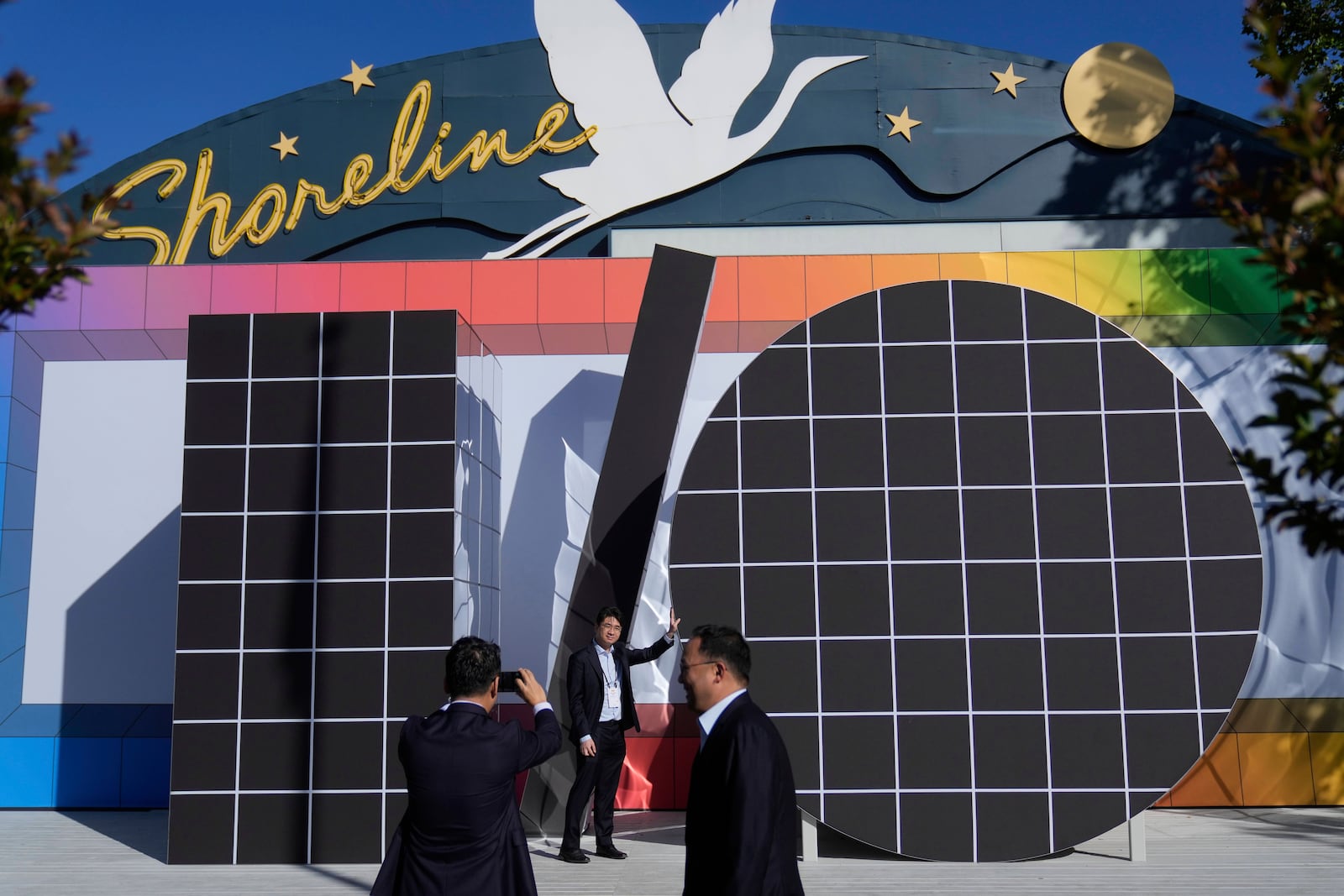 People pose for photos in front of an I/O logo at a Google I/O event in Mountain View, Calif., Tuesday, May 20, 2025. (AP Photo/Jeff Chiu)