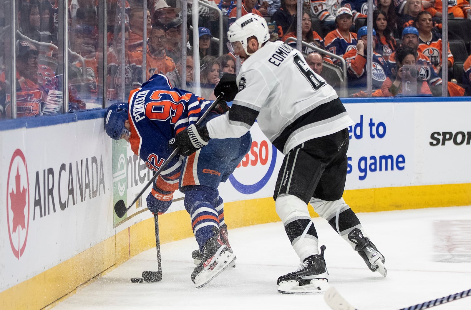 Los Angeles Kings' Joel Edmundson (6) checks Edmonton Oilers' Vasily Podkolzin (92) during the second period of an NHL hockey game in Edmonton, Alberta, Thursday, May 1, 2025. (Jason Franson/The Canadian Press via AP)