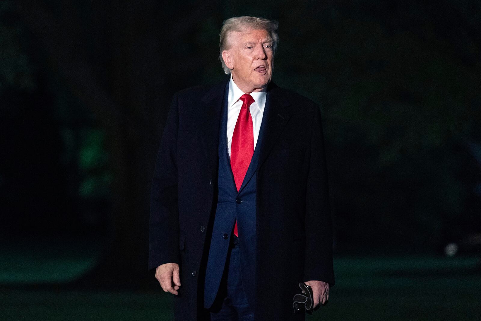 President Donald Trump talks to reporters as he walks on the South Lawn of the White House in Washington, Sunday, April 13, 2025. (AP Photo/Jose Luis Magana)