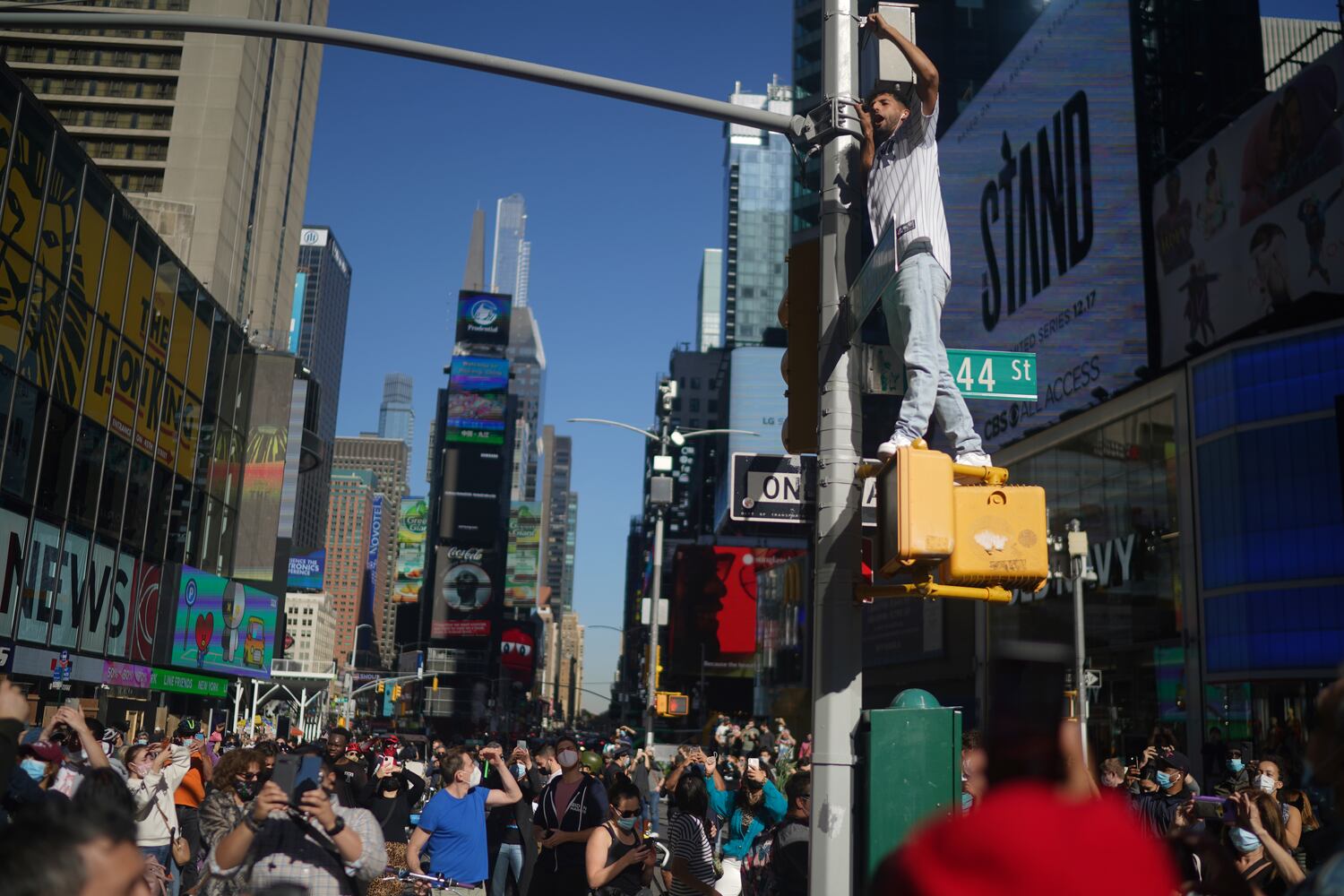 People celebrate after it was announced that Joe Biden was elected the 46th president of the United States, on Saturday, Nov. 7, 2020, in Times Square in New York. President-elect Biden achieved victory offering a message of healing and unity. He will return to Washington facing a daunting set of crises. (Chang W. Lee/The New York Times)