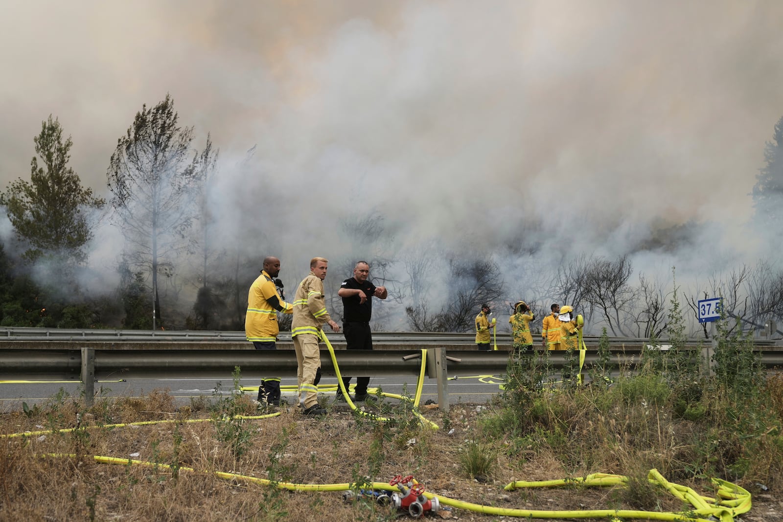 Israeli firefighters work to extinguish a forest fire burning on a freeway to Jerusalem, Wednesday, April 30, 2025. (AP Photo/Mahmoud Illean)