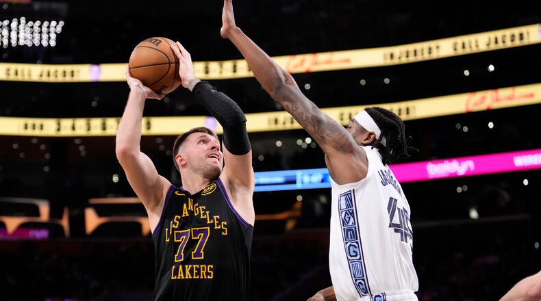 Los Angeles Lakers guard Luka Doncic, left, shoots as Memphis Grizzlies forward GG Jackson defends during the second half of an NBA basketball game Friday, Jan. 2, 2026, in Los Angeles. (AP Photo/Mark J. Terrill)