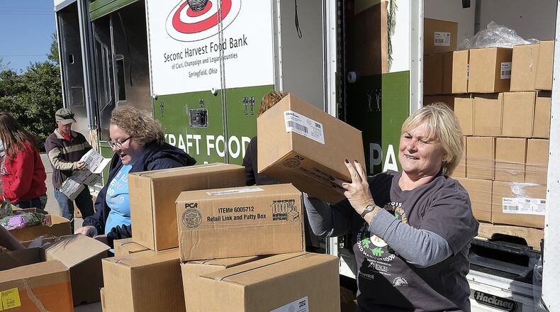 Volunteers unload food from the Second Harvest Food Bank’s Mobile Food Pantry. BILL LACKEY/STAFF