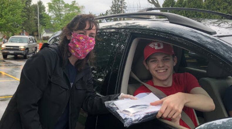 In May, Kettering Fairmont teachers, including Christina Martin here, passed out caps and gowns to the seniors they had in homeroom the past four years, like Matt Pennington (in car). CONTRIBUTED PHOTO