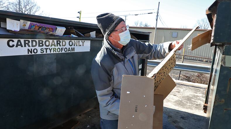 Mike Lyons puts pieces of cardboard in the recycling bin at the recycling center on West Main Street in Springfield Thursday. BILL LACKEY/STAFF