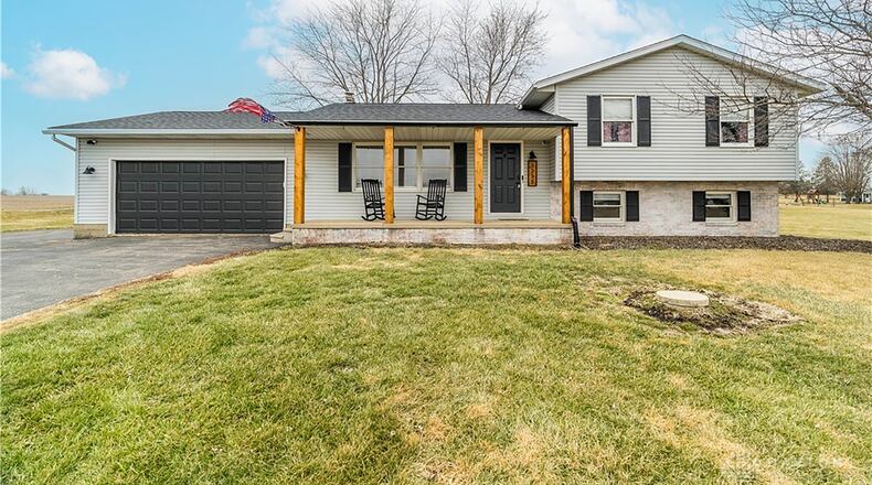 This quad level has a covered front porch and sits well back on the five acre property. It also has a two car attached garage.