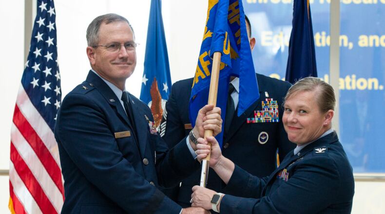 Brig. Gen. James Dienst, 711th Human Performance Wing commander, passes the U.S. Air Force School of Aerospace Medicine flag to Col. Theresa Goodman in a Change of Command ceremony July 19 to symbolize the change of command. (U.S. Air Force photo/Wesley Farnsworth)