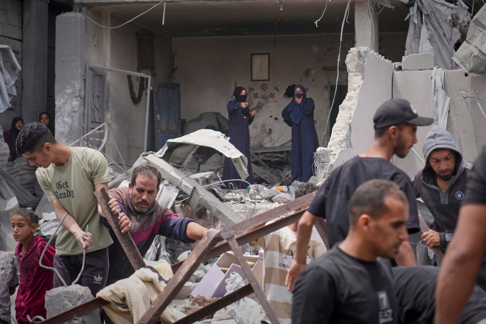 Palestinians search the rubble of a house targeted by an Israeli army strike that killed killing at least five members of the Abu Sahloul family in Khan Younis, in the southern Gaza Strip, Thursday, May 1, 2025. (AP Photo/Abdel Kareem Hana)