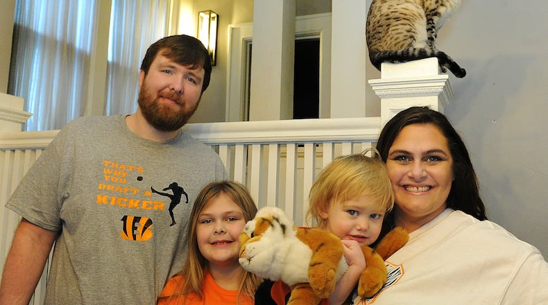 The Young family of Piqua: from left, Brandon, Lily, 9; Ivy, 2; and Melissa, are lifelong Bengal fans. MARSHALL GORBY/STAFF