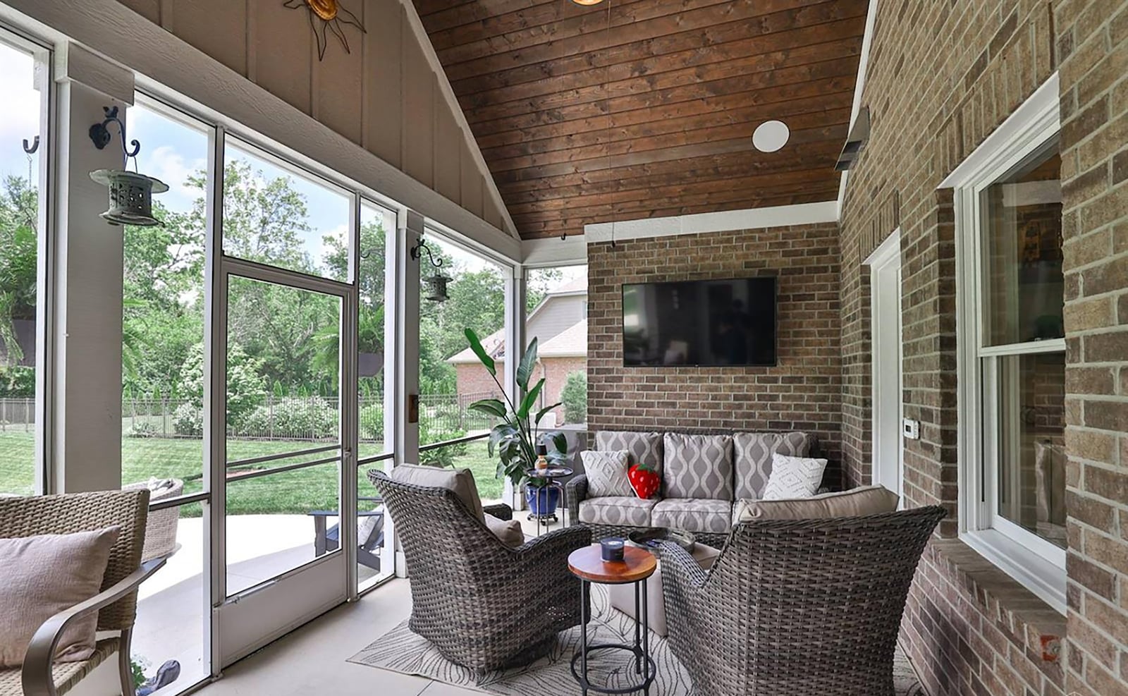 The screened in porch has a vaulted ceiling, concrete floor, ceiling fan and door leading out to the patio. CONTRIBUTED