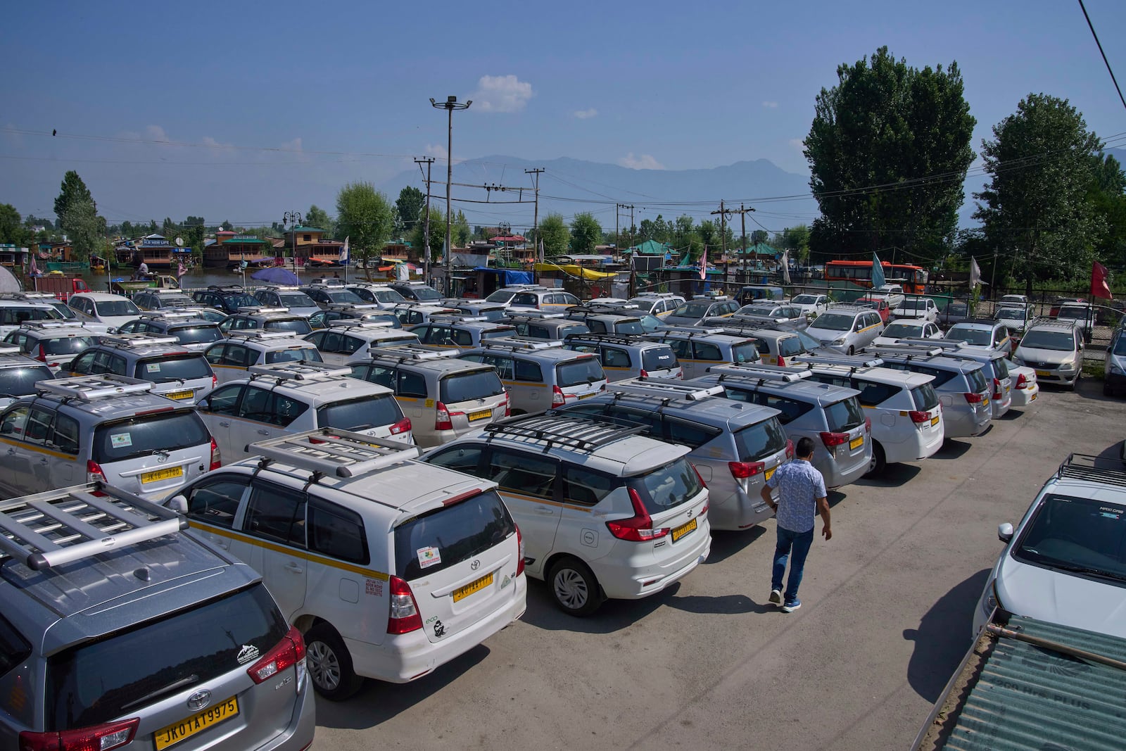A Kashmiri taxi driver walks past hundreds of tourist cabs parked idle in Srinagar, Indian controlled Kashmir, India, Tuesday, May 20, 2025. (AP Photo/Dar Yasin)