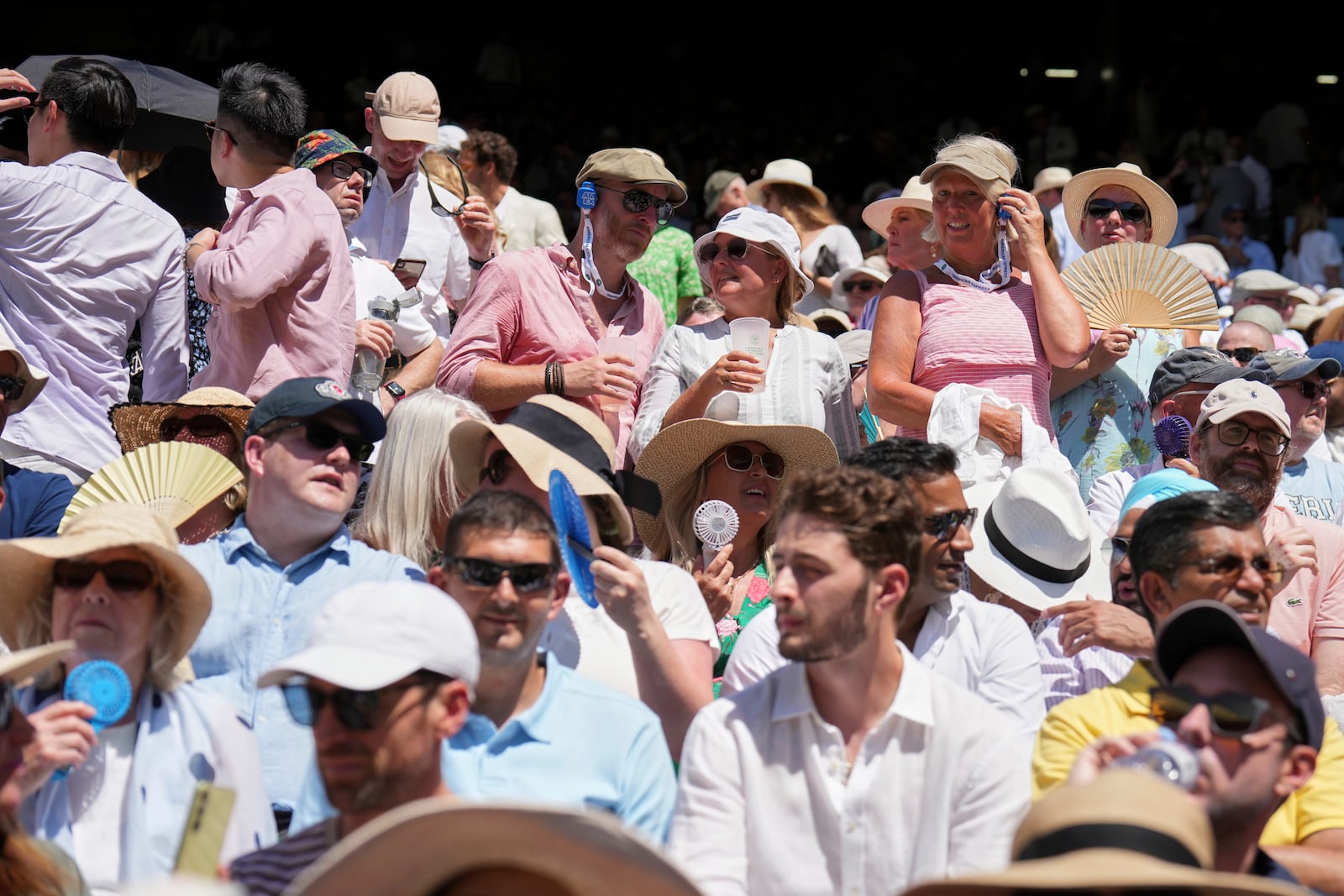 The crowd swelter as Taylor Fritz of the U.S. plays Spain's Carlos Alcaraz in a men's singles semifinal at the Wimbledon Tennis Championships in London, Friday, July 11, 2025. (AP Photo/Kin Cheung)