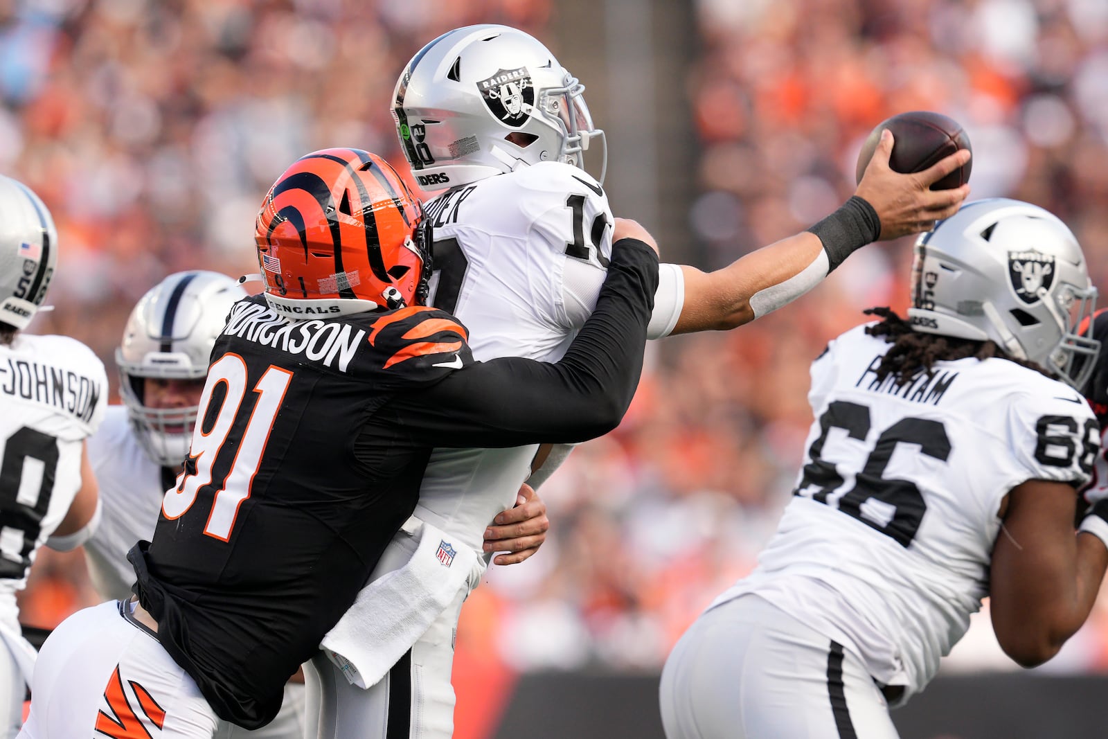 Cincinnati Bengals defensive end Trey Hendrickson, left, sacks Las Vegas Raiders quarterback Desmond Ridder during the second half of an NFL football game in Cincinnati, Sunday, Nov. 3, 2024. (AP Photo/Jeff Dean)