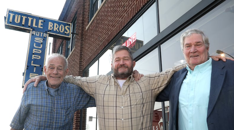 The Tuttle brothers, from left, Rob, Curt and Tom in front of the Tuttle Bros. Building in downtown Springfield. BILL LACKEY/STAFF