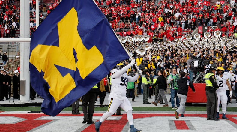 FILE - Michigan defensive lineman Cam Goode waves a Michigan flag after their win over Ohio State in an NCAA college football game ,Nov. 26, 2022, in Columbus, Ohio. (AP Photo/Jay LaPrete, File)