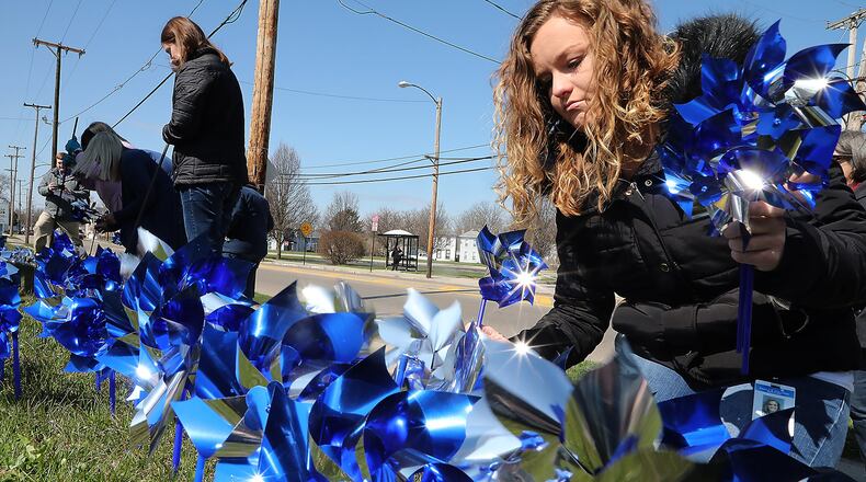 Natasha Foster, right, and other members of the Clark County Family & Children’s Services put out pinwheels in front of the Department of Jobs and Family Services building during the 2018 recognition of Child Abuse Prevention month, which occurs nationally every April. Bill Lackey/Staff