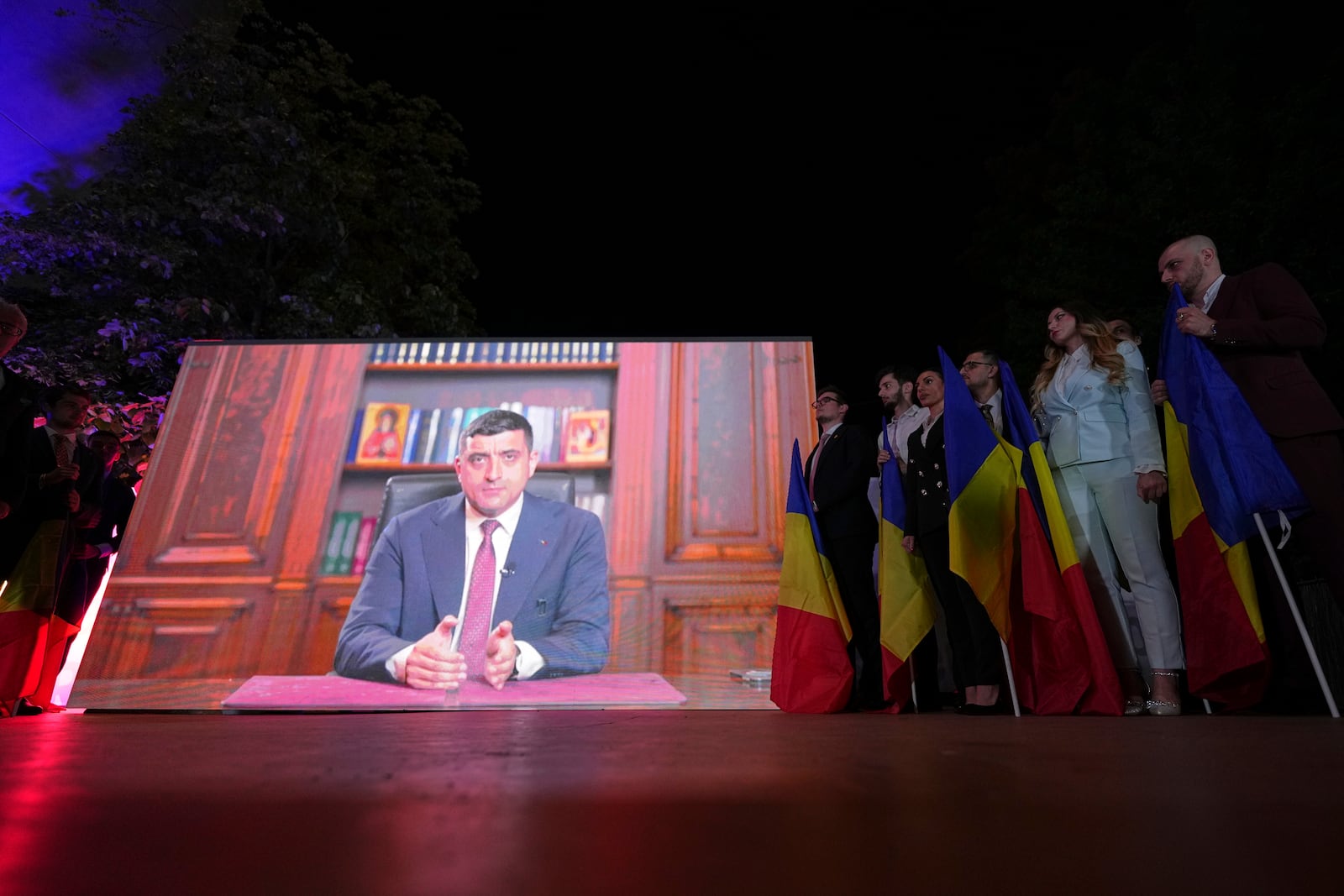 Presidential candidate George Simion is shown on a screen at the meeting of his supporters after polls closed for the first round of the country's presidential election redo in Bucharest, Romania, Sunday, May 4, 2025. (AP Photo/Andreea Alexandru)