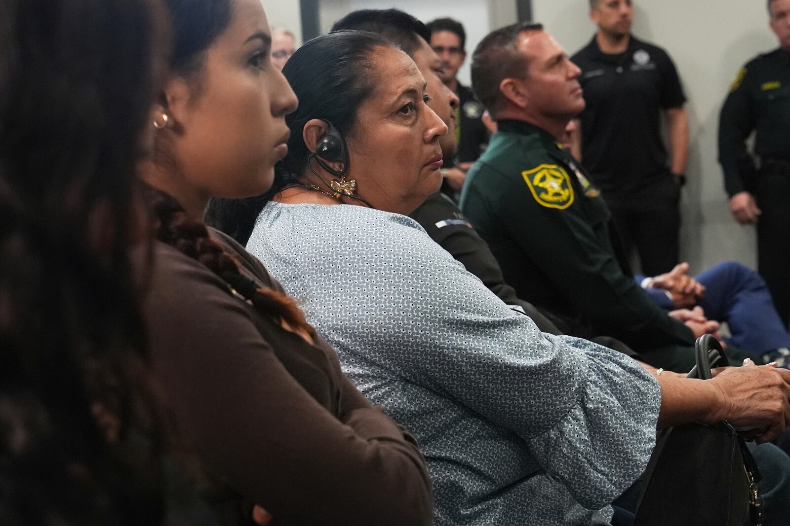 Family members of a homicide victim listen to U.S. Attorney General Pam Bondi announce the arrest of gang members involved in four homicides, Friday, April 4, 2025, in Fort Lauderdale, Fla. (AP Photo/Marta Lavandier)