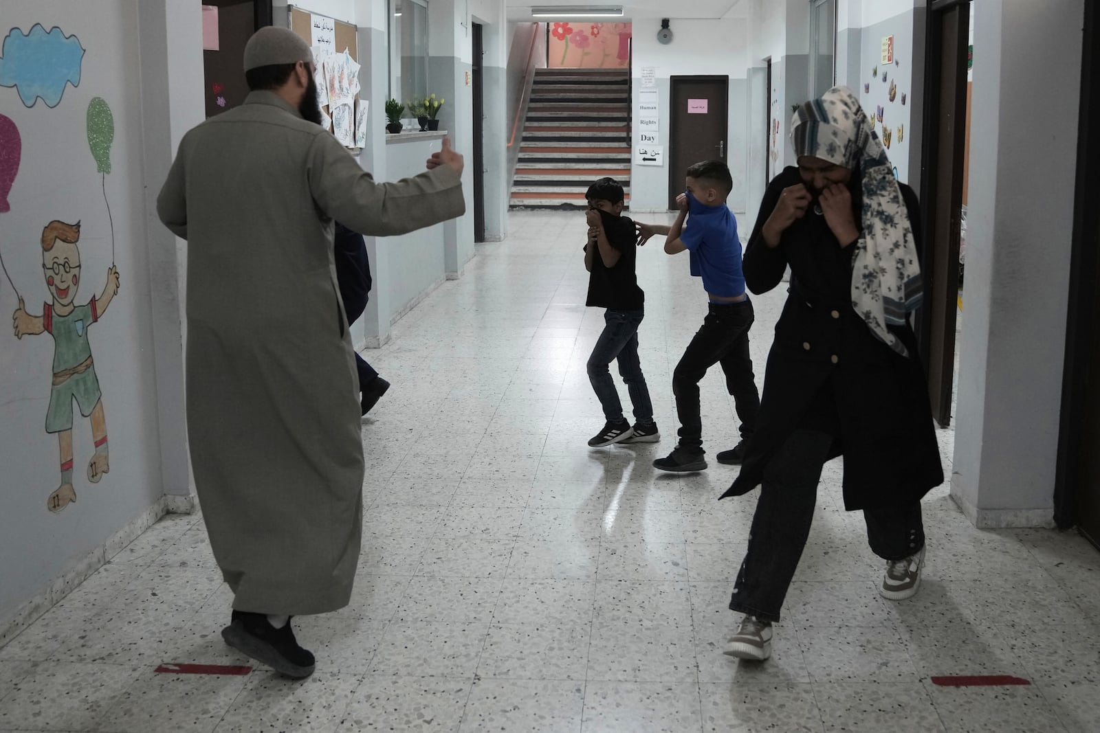 Students and teachers react to tear gas fired by Israeli Police into in the yard of the UNRWA Boys' School run by the U.N. agency for Palestinian refugees in the Shuafat Refugee Camp in east Jerusalem, Tuesday, April 29, 2025.(AP Photo/Mahmoud Illean)