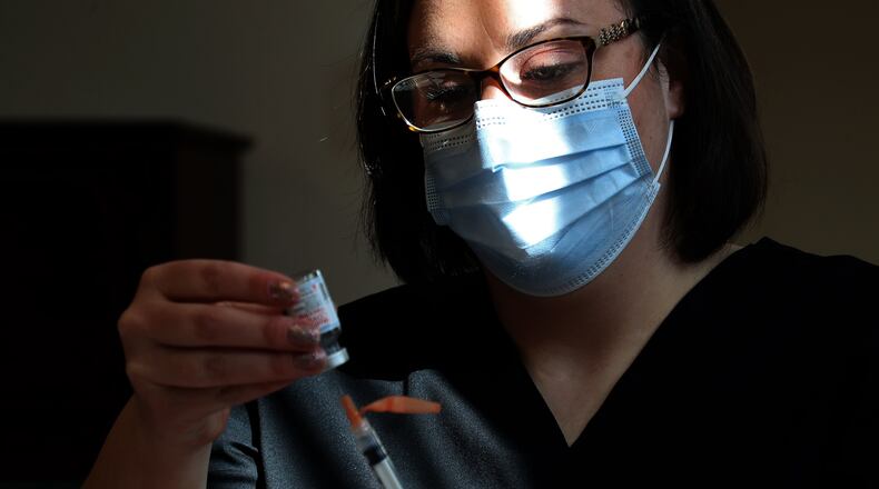 Cheyenne Bumgarner, a nurse at the Clark County Combined Health District, loads a syringe with the COVID vaccine during a clinic at the Shawnee Place apartments on March 5. Clark County has seen a slight uptick in COVID-19 confirmed cases over the last weeks, a sign some might be letting their guard down as warm weather returns. BILL LACKEY/STAFF