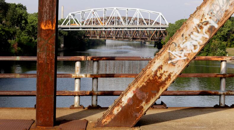 FILE - This Sept. 11, 2013, file photo shows the bridge on Western Avenue over the Cal-Sag Channel framed by the rusted supports of the closed Chatham St. bridge in Blue Island, Ill. The Western Avenue bridge was classified as both "structurally deficient" and "fracture critical" in federal data for 2012. An analysis of Transportation Department data released by the American Road & Transportation Builders Association on Feb. 15, 2017, says more than 55,000 bridges in the U.S. have been deemed structurally deficient. (AP Photo/M. Spencer Green, File)