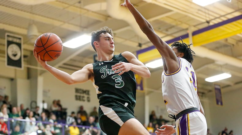 Cathoilc Central High School senior Ashton Young looks to pass the ball while being guarded by Emmanuel Christian's Justus Channels during their game on Thursday night in Springfield. The Irish won 55-40. CONTRIBUTED PHOTO BY MICHAEL COOPER