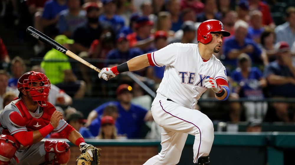 FILE - Texas Rangers' Carlos Beltran follows through on a two-run home run swing as Los Angeles Angels catcher Carlos Perez watches in the fifth inning of a baseball game, Sept. 21, 2016, in Arlington, Texas. (AP Photo/Tony Gutierrez, File)