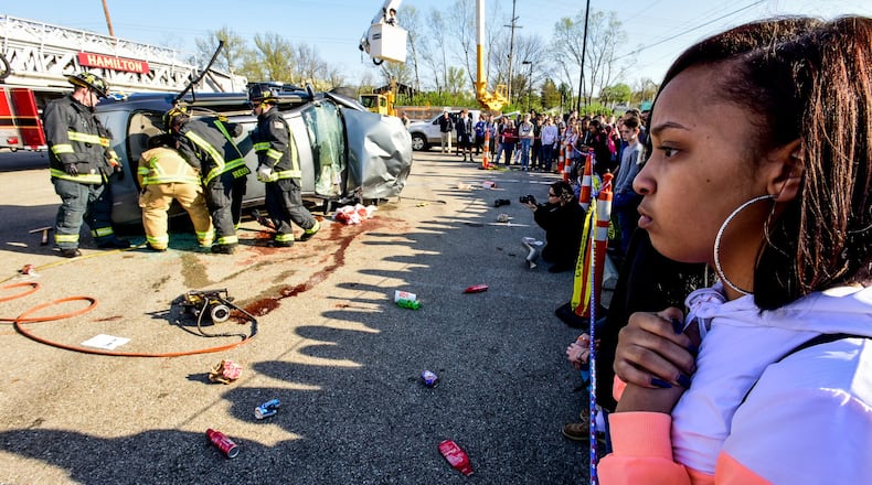 Hamilton High School senior Jordan Thompson, right, reacts as The Greater Hamilton Safety Council, Hamilton High School Students and the Hamilton police and fire departments present a mock crash to share with students the dangers of distracted driving Wednesday, April 12 at Hamilton High School. NICK GRAHAM/STAFF