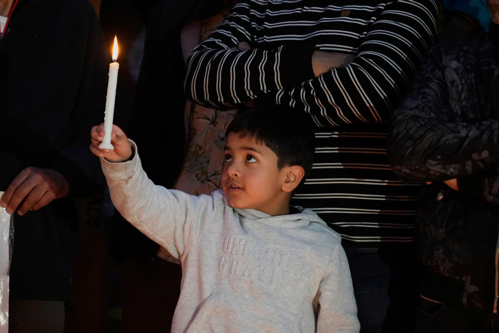 A child holds a candle during a candlelight protest in Srinagar, Indian controlled Kashmir, Wednesday, April 23, 2025, a day after an attack killed at least 26 people, most of them tourists. (AP Photo/Mukhtar Khan)