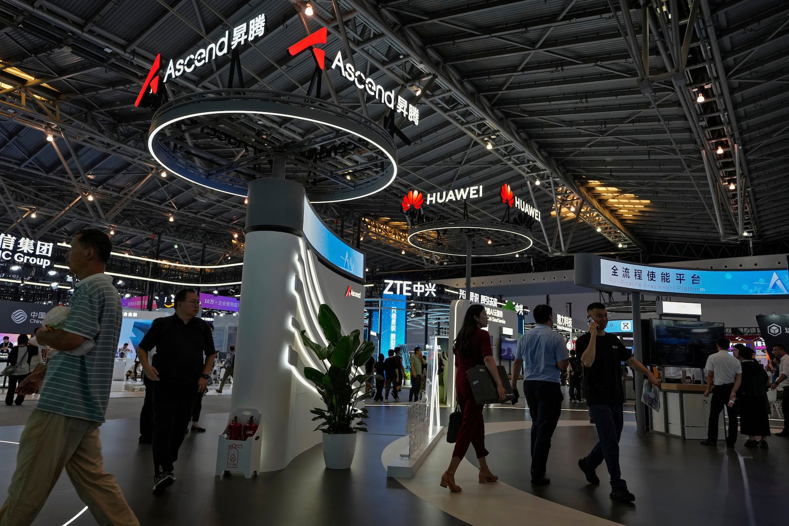 FILE - People visit the Ascend AI exhibition booth by Huawei during the 2024 The World Artificial Intelligence Conference (WAIC) & High-Level Meeting on Global AI Governance with the theme "Governing AI for Good and for All" at the Shanghai Expo Center Multifunction Hall in Shanghai China on July 4, 2024. (AP Photo/Andy Wong, File)