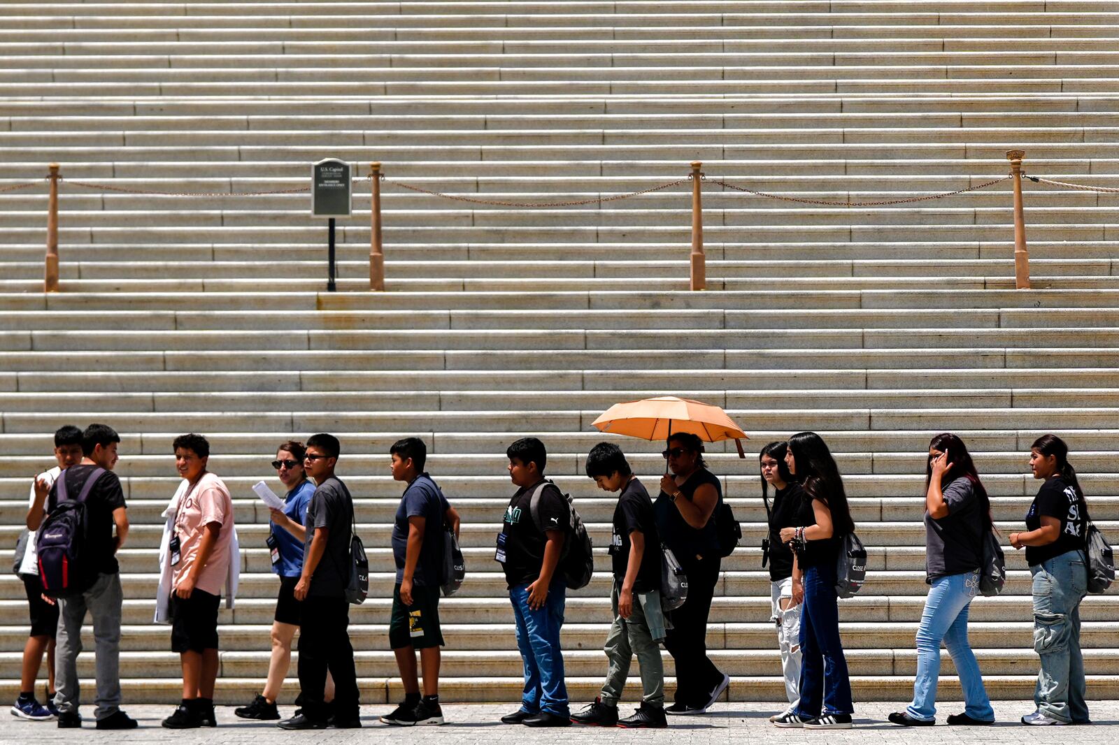 A person uses an umbrella to shield themselves from the sun, Wednesday, June 25, 2025, outside the U.S. Capitol in Washington. (AP Photo/Julia Demaree Nikhinson)