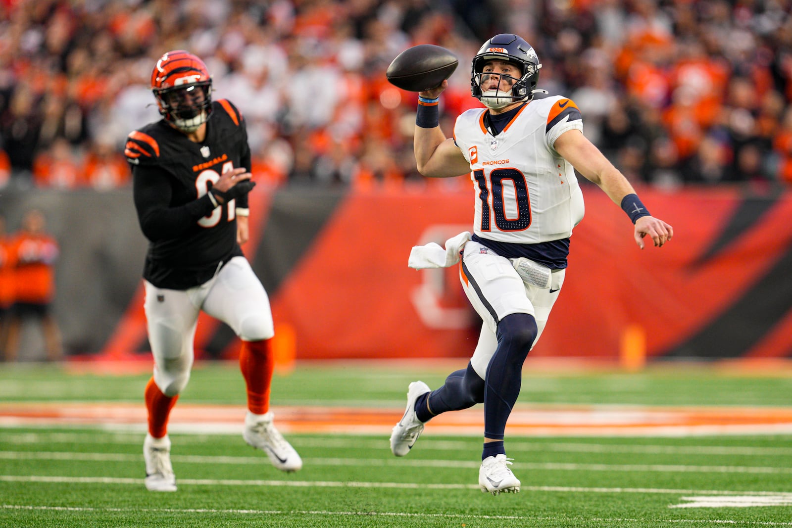 Denver Broncos quarterback Bo Nix (10) threw in front of Cincinnati Bengals defensive end Trey Hendrickson (91) during the first half of an NFL football game in Cincinnati, Saturday, Dec. 28, 2024. (AP Photo/Jeff Dean)