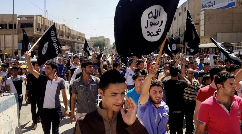 FILE - Demonstrators chant pro-Islamic State slogans as they carry the group's flags in front of the provincial government headquarters in Mosul, 225 miles (360 kilometers) northwest of Baghdad on June 16, 2014. (AP Photo, File)