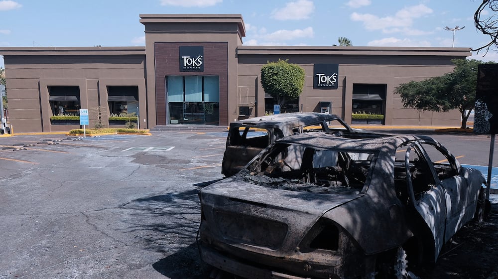 Charred vehicles sit in a parking lot sit outside a shopping mall in Guadalajara, Jalisco state, Mexico, Sunday, Feb. 22, 2026, as authorities reported that the Mexican Army killed Jalisco New Generation Cartel leader Nemesio Oseguera, known as "El Mencho." (AP Photo/Alejandra Leyva)